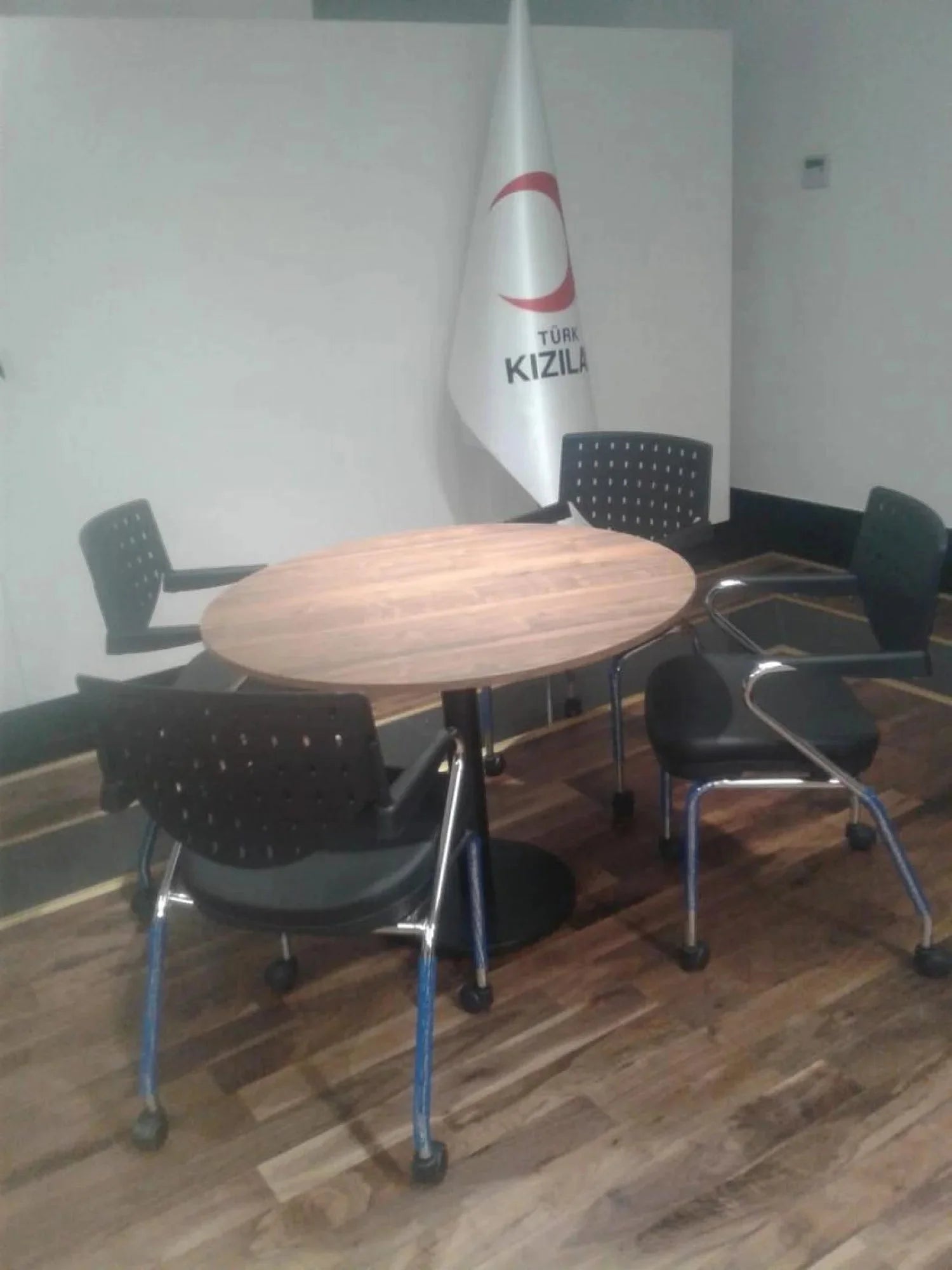 İstanbul Ofis Mobilya ahşap tablalı yuvarlak toplantı masası ve dört adet siyah ofis sandalyesi