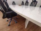 İstanbul Ofis Mobilya beyaz oval toplantı masası, modern ofis tasarımı ve siyah ergonomik çalışma sandalyeleri ile.