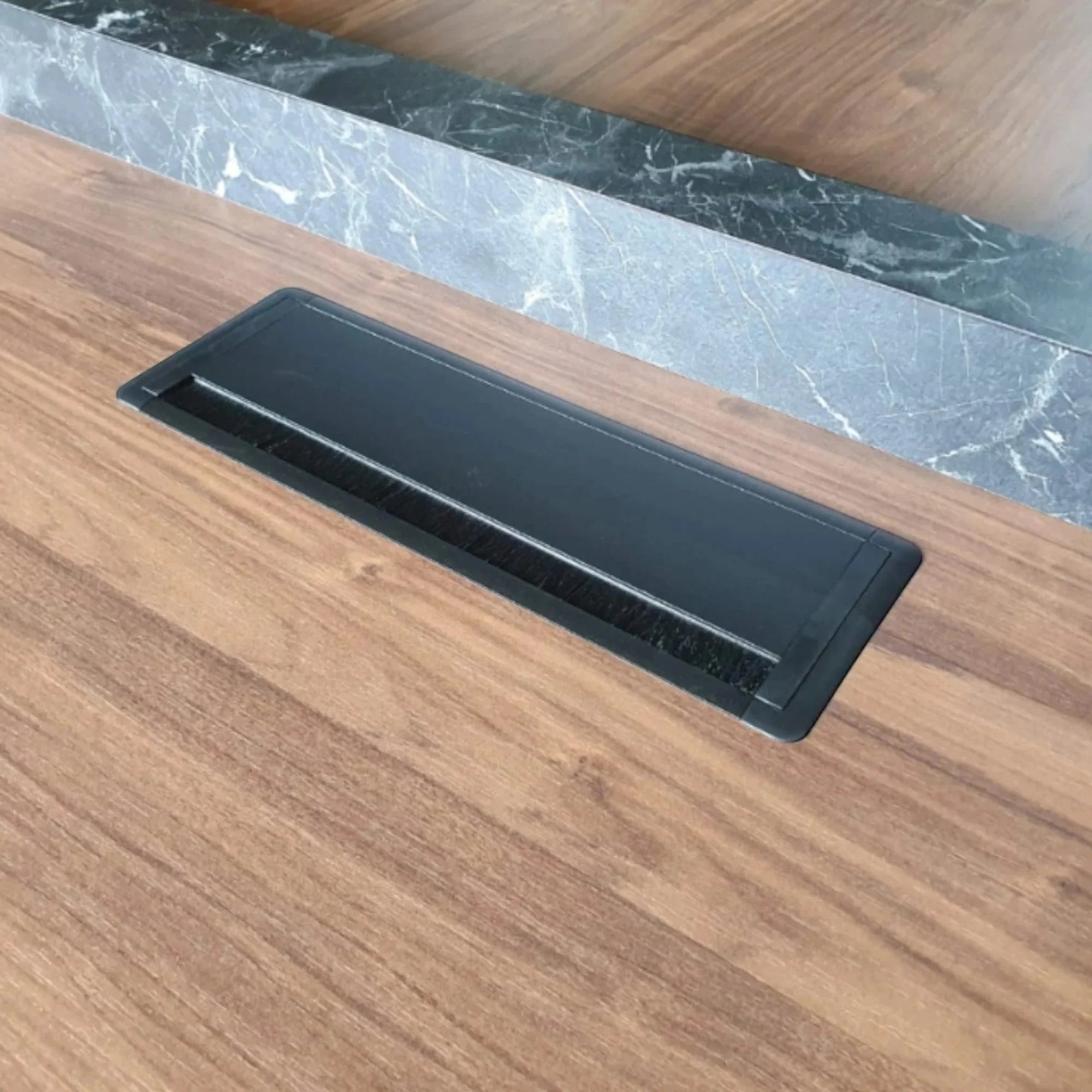 İstanbul Ofis Mobilya modern toplantı masası, ahşap yüzey, mermer detay ve entegre siyah kablo yönetim sistemi.
