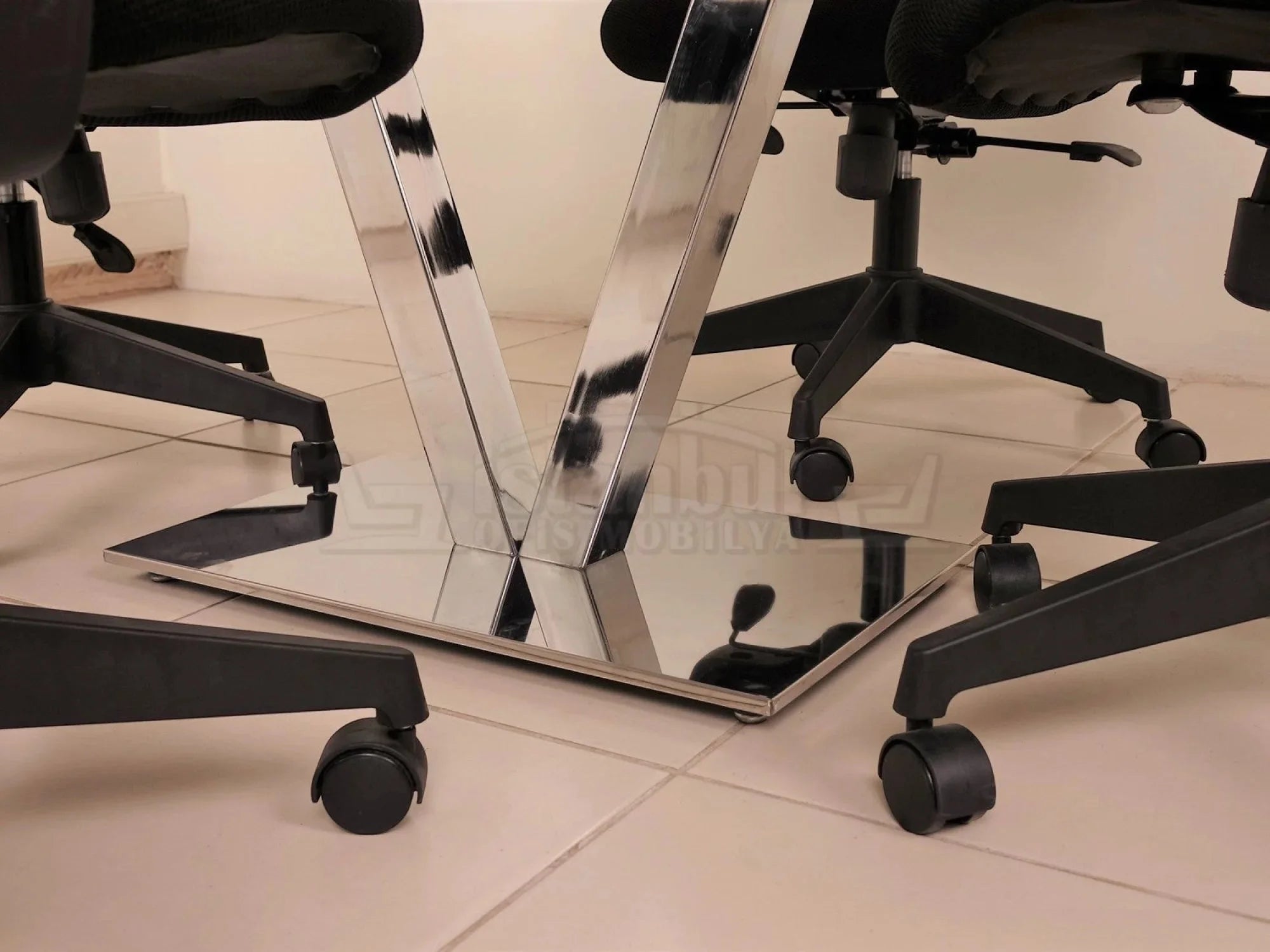 İstanbul Ofis Mobilya Viyana kare toplantı masasının V formlu parlak krom metal ayak detayı ve tekerlekli ofis sandalyeleri